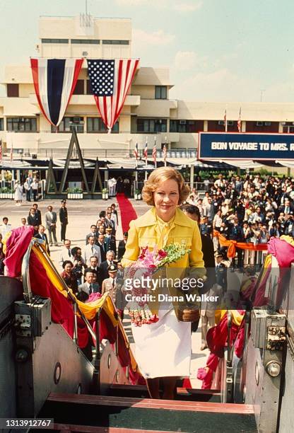 View of US First Lady Rosalynn Carter as she climbs the staircase to her plane after a 'bon voyage' ceremony at the Don Mueang International Airport,...