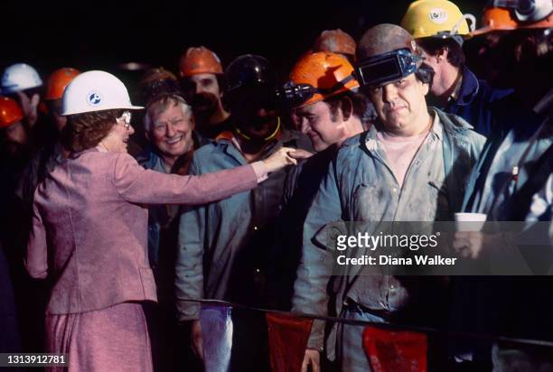 First Lady Rosalynn Carter shakes hands with a group of men, many with welding glasses and hardhats, as she attends an event in support of her...