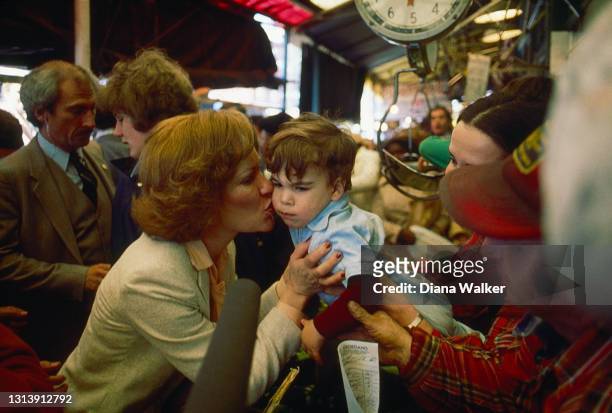 First Lady Rosalynn Carter kisses a young boy held aloft at an event in support of her husband's Presidential re-election campaign, April 1980.