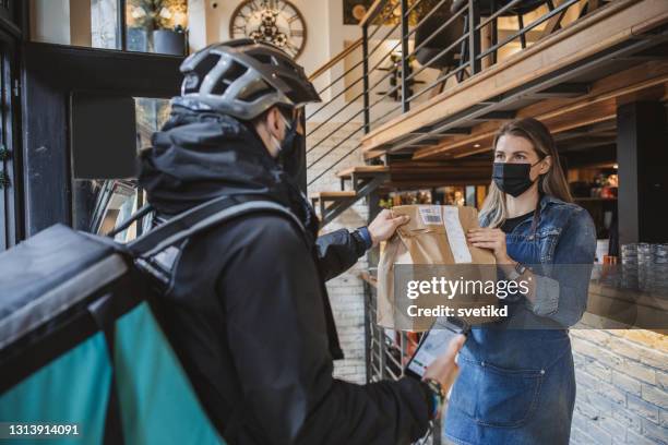 liefermann holt lebensmittelbestellung ab - zuhause-bleiben-anordnung stock-fotos und bilder