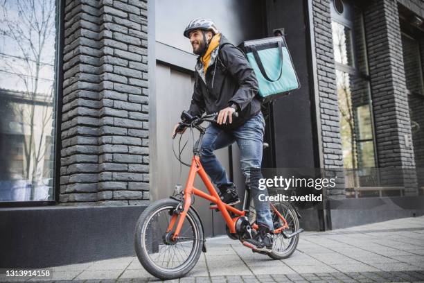 stadtzustellung auf dem fahrrad - elektro fahrrad stock-fotos und bilder