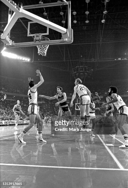 Phoenix Suns guard Paul Westphal flips the ball to a teammate as he drives toward Denver Nuggets forward Bobby Jones and Nuggets center Dan Issel...