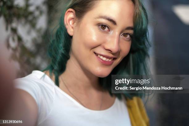 young woman with green hair taking a selfie, smiling and looking at the camera in mexico city, pov of camera - generation z selfie stock pictures, royalty-free photos & images