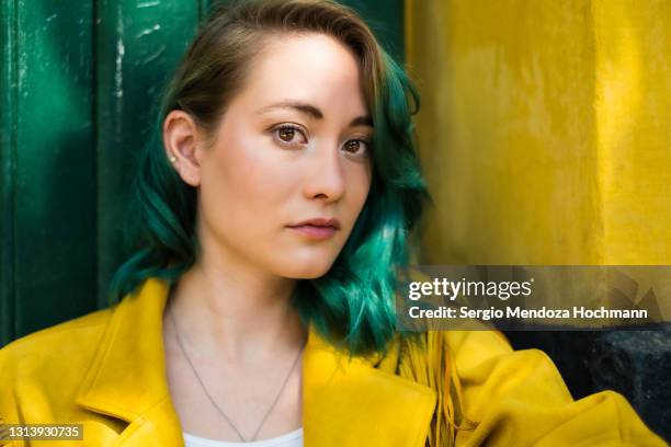 young woman with green hair looking at the camera in mexico city - green hair stock pictures, royalty-free photos & images