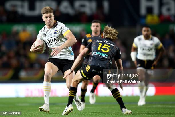 Jordie Barrett of the Hurricanes is tackled by Damian McKenzie of the Chiefs during the round nine Super Rugby Aotearoa match between the Chiefs and...