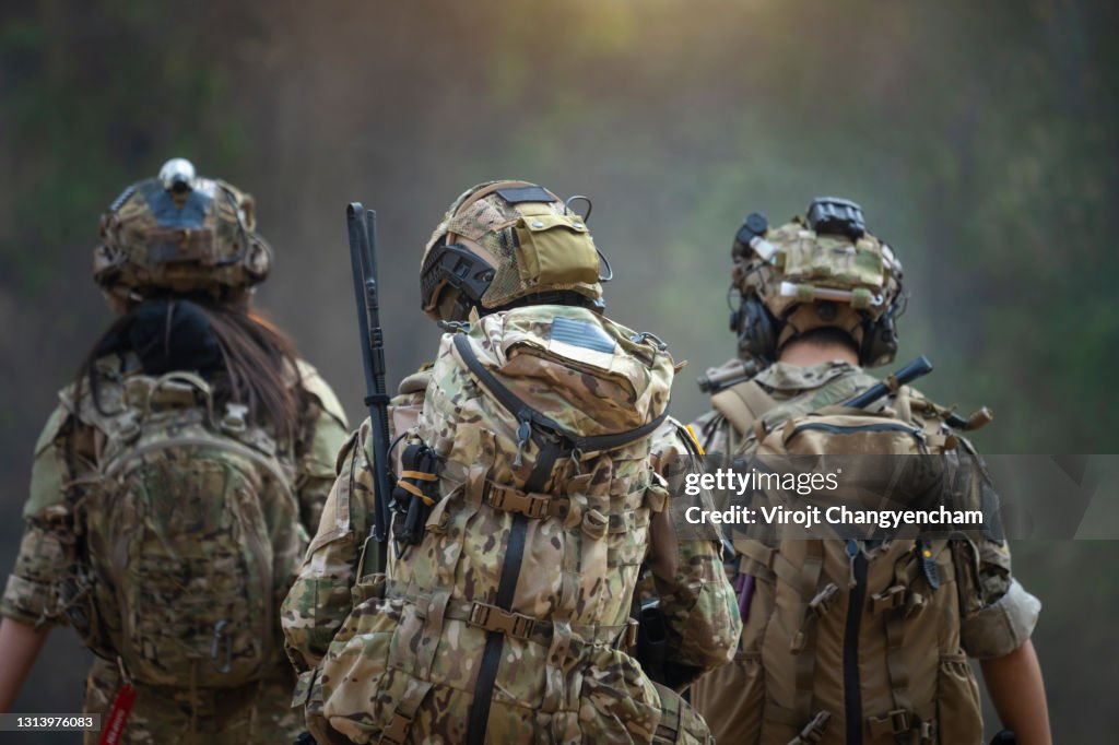 Rear of soldiers patrolling along the risky area.
