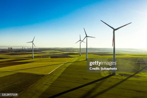 vista aérea de los aerogeneradores y el campo agrícola - fundo azul fotografías e imágenes de stock