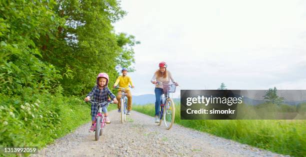 familienfahrräder auf landstraße - bicycle daughter stock-fotos und bilder