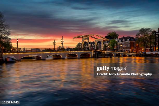 skinny bridge, amstel river, amsterdam, netherlands. - amsterdam dusk evening foto e immagini stock