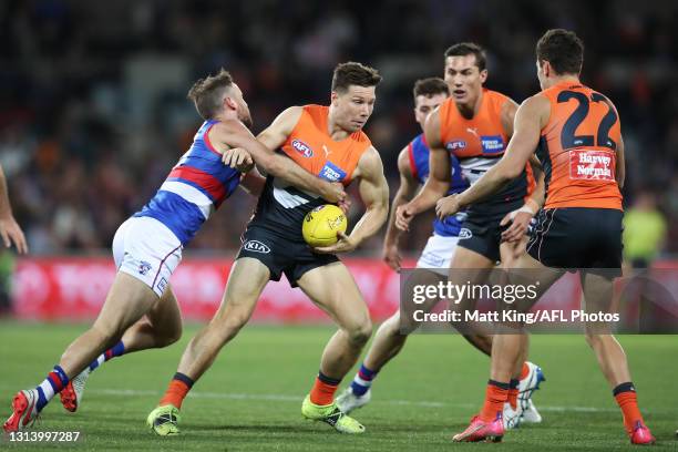 Toby Greene of the Giants is tackled during the round six AFL match between the Greater Western Sydney Giants and the Western Bulldogs at Manuka Oval...