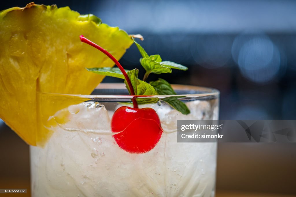 Cocktail with pineapple, cherry and mint leaves