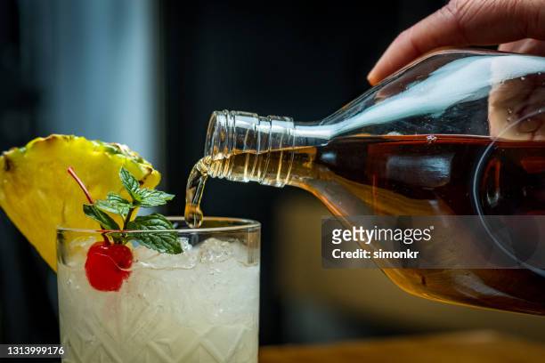 close-up of pouring rum into cocktail drink - rum stock pictures, royalty-free photos & images