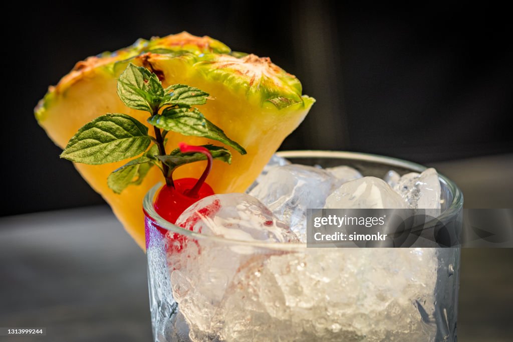 Cocktail with pineapple, cherry and mint leaves