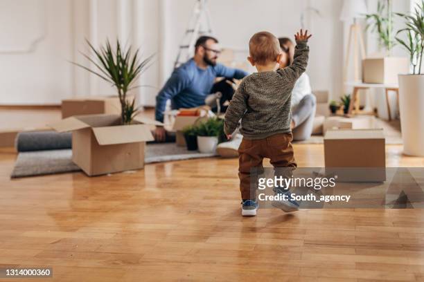 de jongen van de baby met ouders in hun nieuw huis - homeowner stockfoto's en -beelden