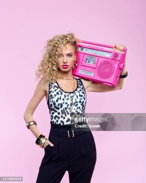 confident woman in 80's style outfit holding boom box - pop musician stock pictures, royalty-free photos & images