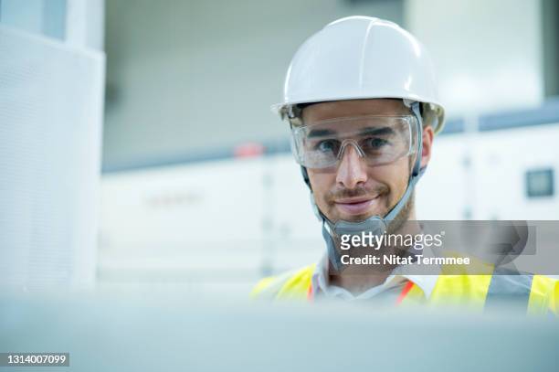 portrait of electrician engineer working in electricity control room of solar cell power station. - regular guy stock pictures, royalty-free photos & images