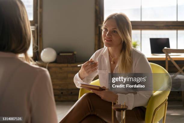 woman psychologist talking to patient - therapist imagens e fotografias de stock