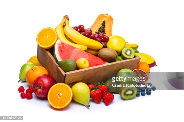 bunte früchte in einer kiste auf weißem hintergrund - obst stock-fotos und bilder