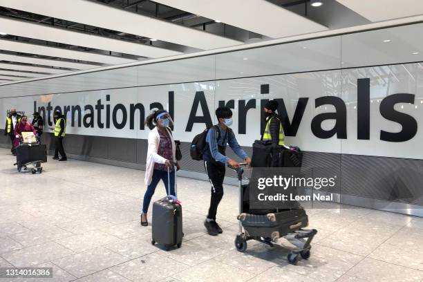 Passengers are escorted through the arrivals area of terminal 5 towards coaches destined for quarantine hotels, after landing at Heathrow airport on...