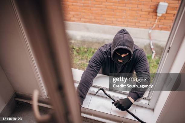 räuber bricht in haus ein - haus einbruch stock-fotos und bilder