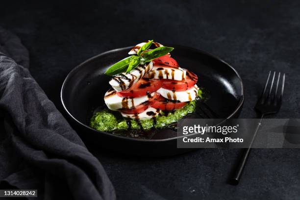 de salade van caprese op zwarte achtergrond - caprese stockfoto's en -beelden