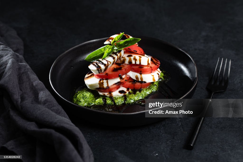Caprese salad on black background