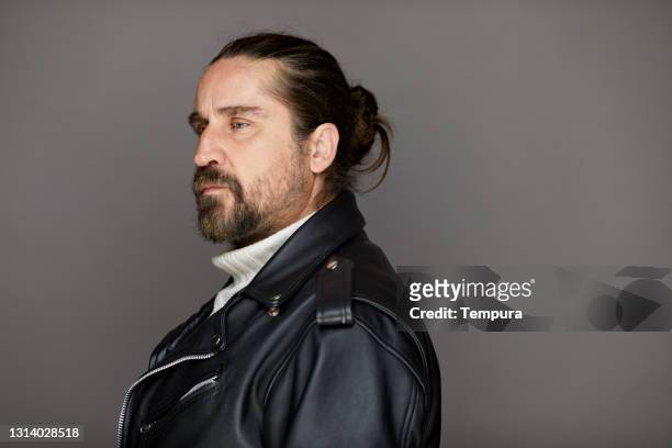 profilansicht eines motorradfahrers mittleren alters in lederjacke. - rockstar stock-fotos und bilder