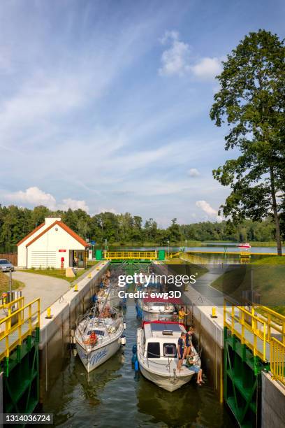 urlaub in polen - segel- und motorboote auf der guzianka-schleuse in masuren - abflussrinne stock-fotos und bilder