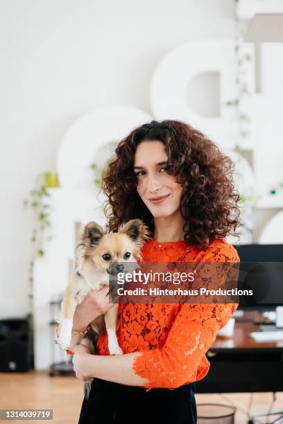portrait of transgender businesswoman holding pet dog - department of interior holds a take your dog to work day stock pictures, royalty-free photos & images