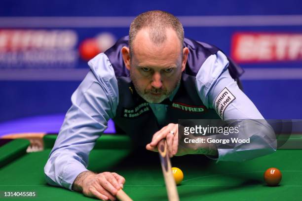 Mark Williams of Wales plays a shot during the Betfred World Snooker Championship Round Two match between Mark Williams of Wales and John Higgins of...