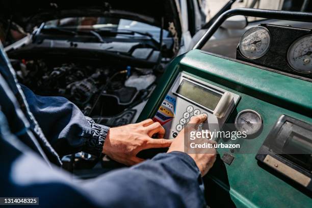 auto mechanic filling the vehicle's air conditioning - compressor stock pictures, royalty-free photos & images