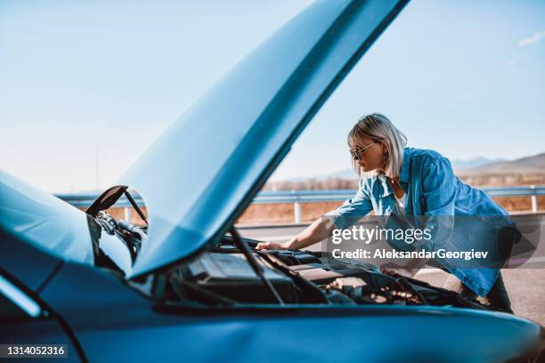 donna che controlla la pressione dell'acqua dell'auto dopo aver bloccato sulla strada - vehicle breakdown foto e immagini stock