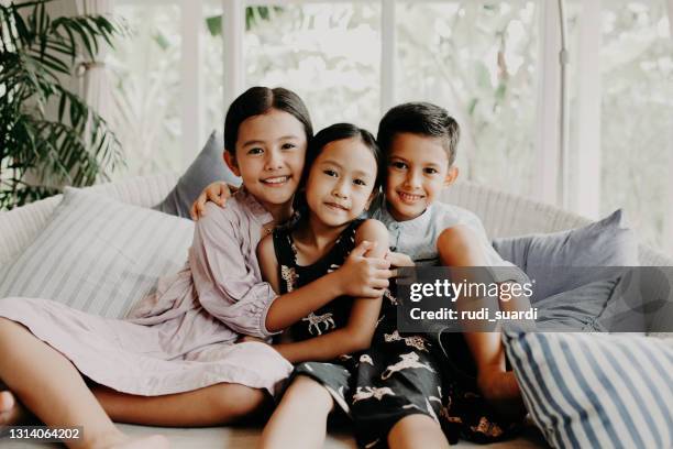 kids  sitting on sofa - kids fun indonesia stock pictures, royalty-free photos & images