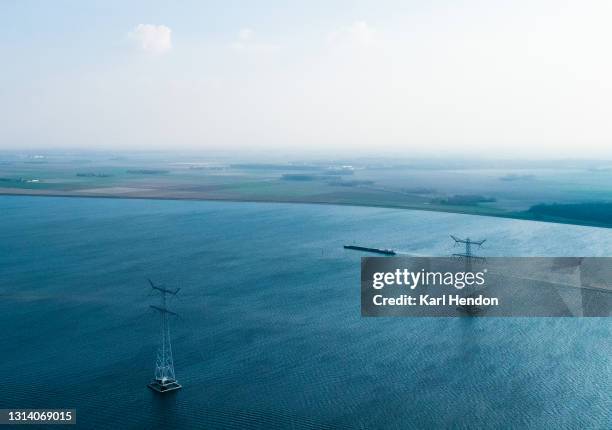 an aerial daytime view of electricity pylons out at sea - stock photo - electricity pylon bildbanksfoton och bilder
