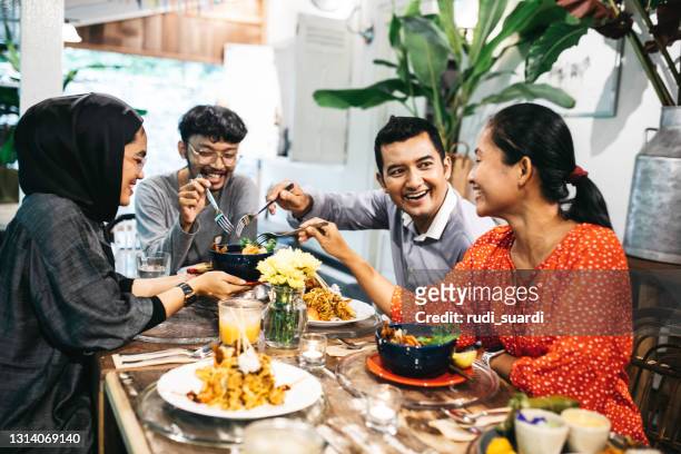 vrienden die een goede tijd bij diner hebben - indonesia stockfoto's en -beelden