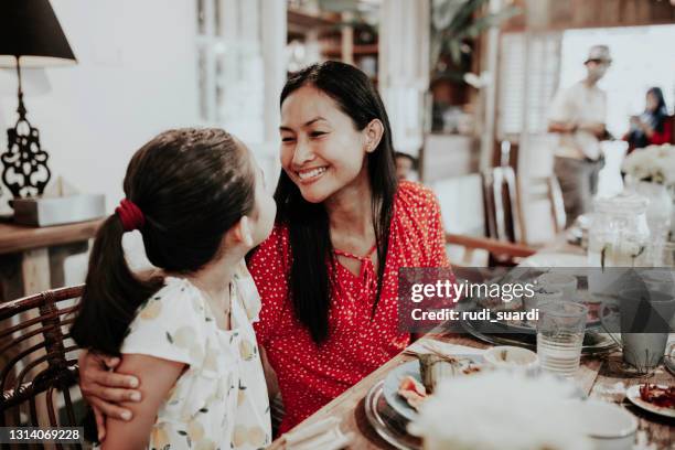 mamma &amp; kind die maaltijd in restaurant hebben - asian family cafe stockfoto's en -beelden