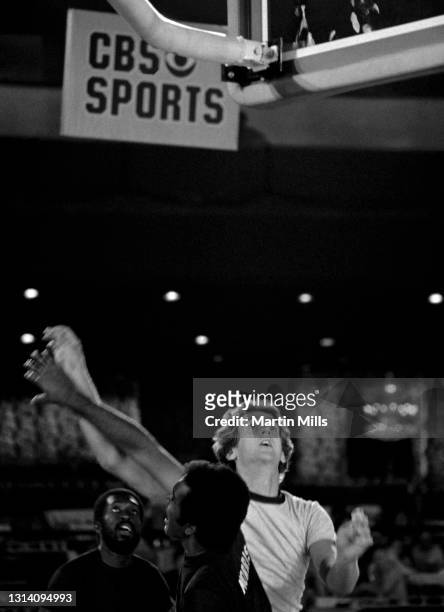 Player of the Phoenix Suns Paul Westphal goes for the shot as he is defended by American actor Greg Morris and NBA player of the New York Knicks Earl...