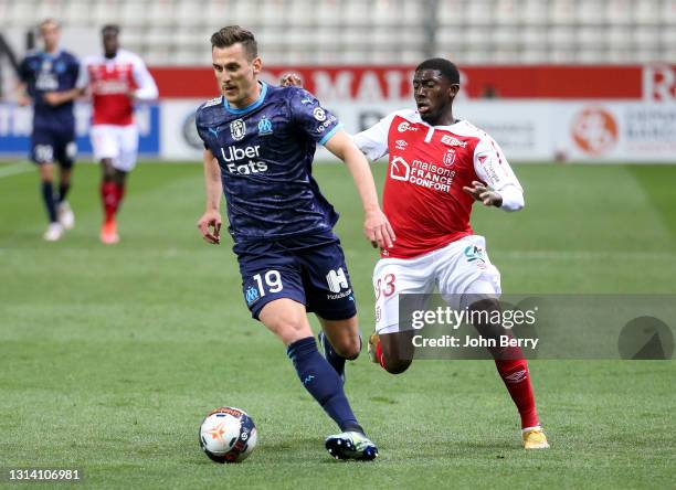 Arkadiusz Milik of Marseille, Fode Doucoure of Reims during the Ligue 1 match between Stade Reims and Olympique de Marseille at Stade Auguste Delaune...