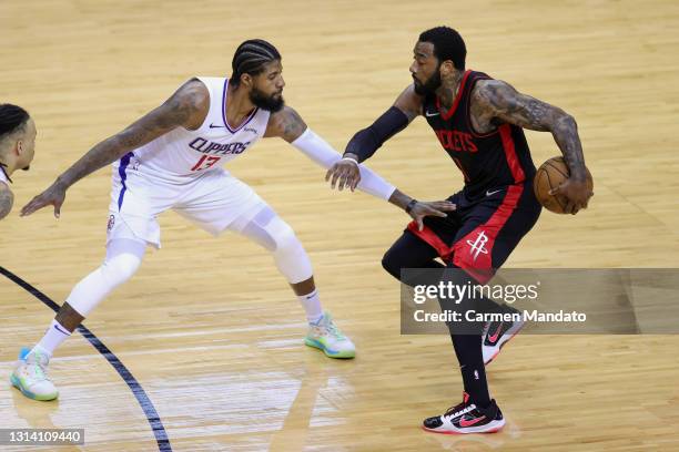 John Wall of the Houston Rockets dribbles against Paul George of the Los Angeles Clippers during the third quarter at Toyota Center on April 23, 2021...