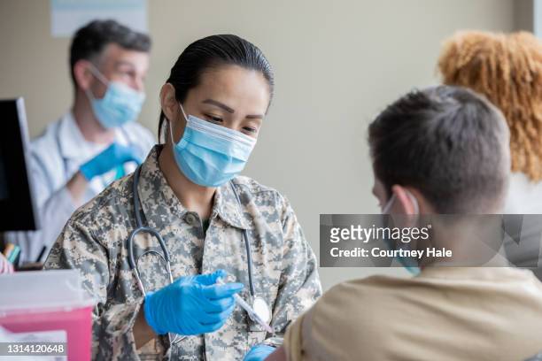 成熟士兵是軍醫注射covid-19疫苗 - 陸軍兵士 個照片及圖片檔
