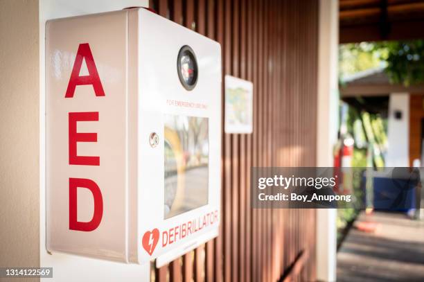 an automated external defibrillator, (aed) placed on the wall in public locations. - desfibrilador fotografías e imágenes de stock