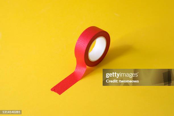 one red adhesive tape on yellow background still life - adhesive tape stock pictures, royalty-free photos & images