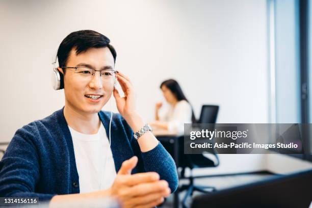 mature asian man having video call on laptop computer in office. - bingo caller stock pictures, royalty-free photos & images