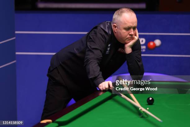 John Higgins of Scotland reacts after missing a shot during the Betfred World Snooker Championship Round Two match between Mark Williams of Wales and...