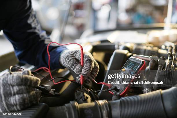 measure electric voltage for car repair - reparatiewerkplaats stockfoto's en -beelden