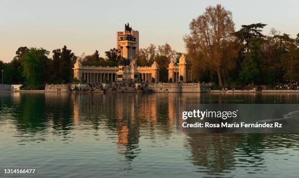 great pond and monument to alfonso xii at the retiro park (parque del buen retiro) in madrid at sunset - madrid buen retiro park stock pictures, royalty-free photos & images