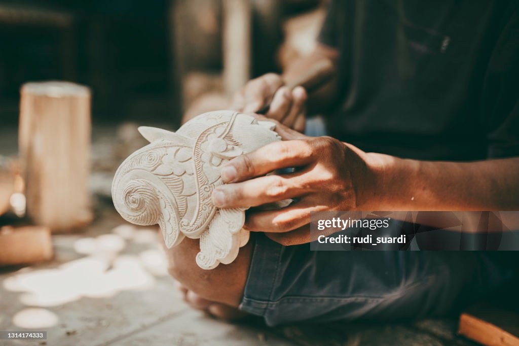 Sculptress carving wooden figure