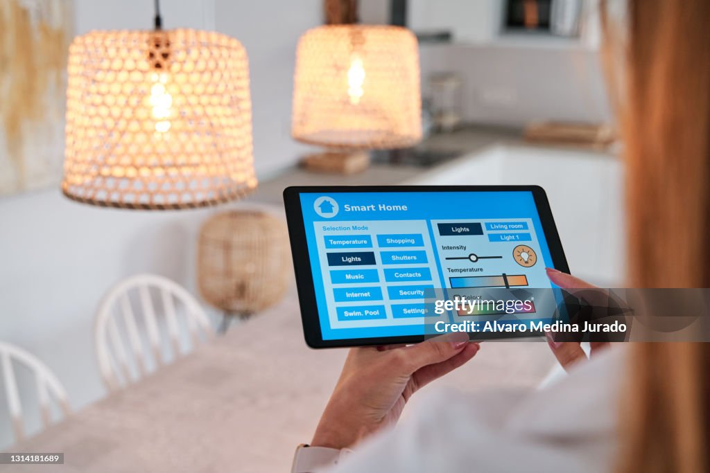 Woman using an app on her smartphone to control the lighting in her smart home