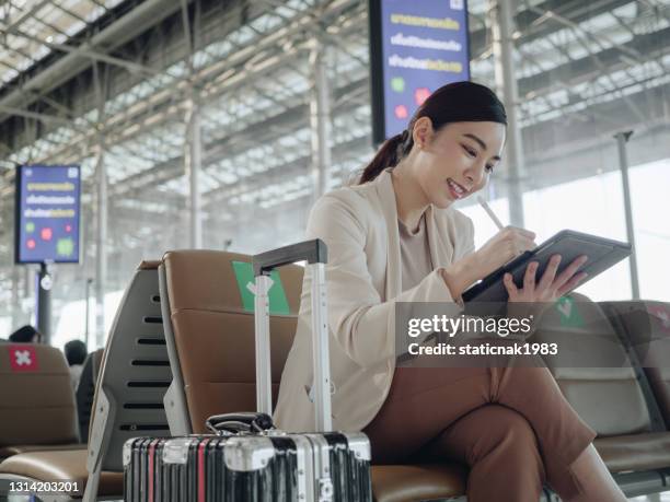 donna d'affari asiatica in attesa di aeroplano. - aeroporto di suvarnabhumi foto e immagini stock