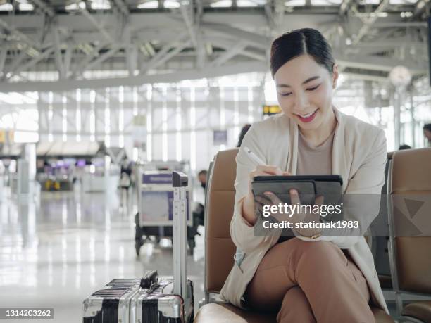 donna d'affari asiatica in attesa di aeroplano. - aeroporto di suvarnabhumi foto e immagini stock